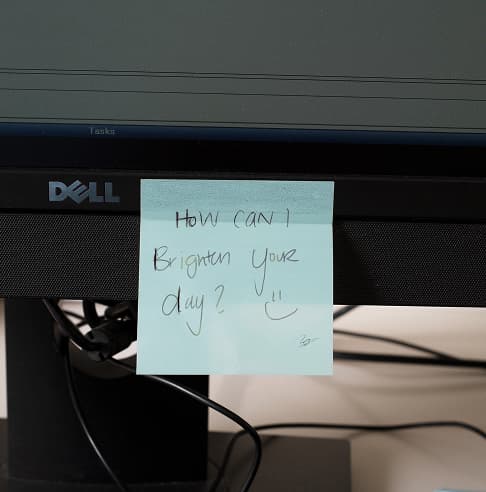 A friendly handwritten note attached to a monitor.