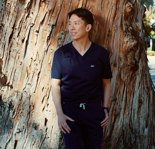 A care professional standing beside a tree.