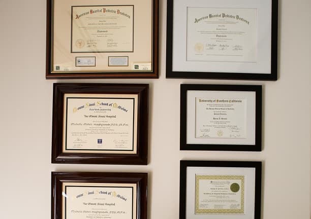 Professional credentials displayed on a wall.