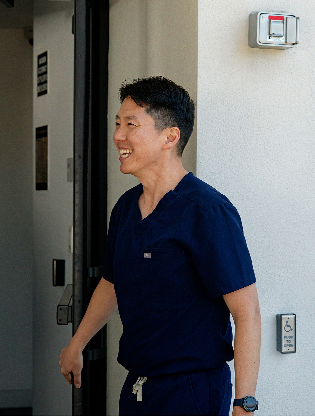 Care professional opening a door in a bright, welcoming setting.
